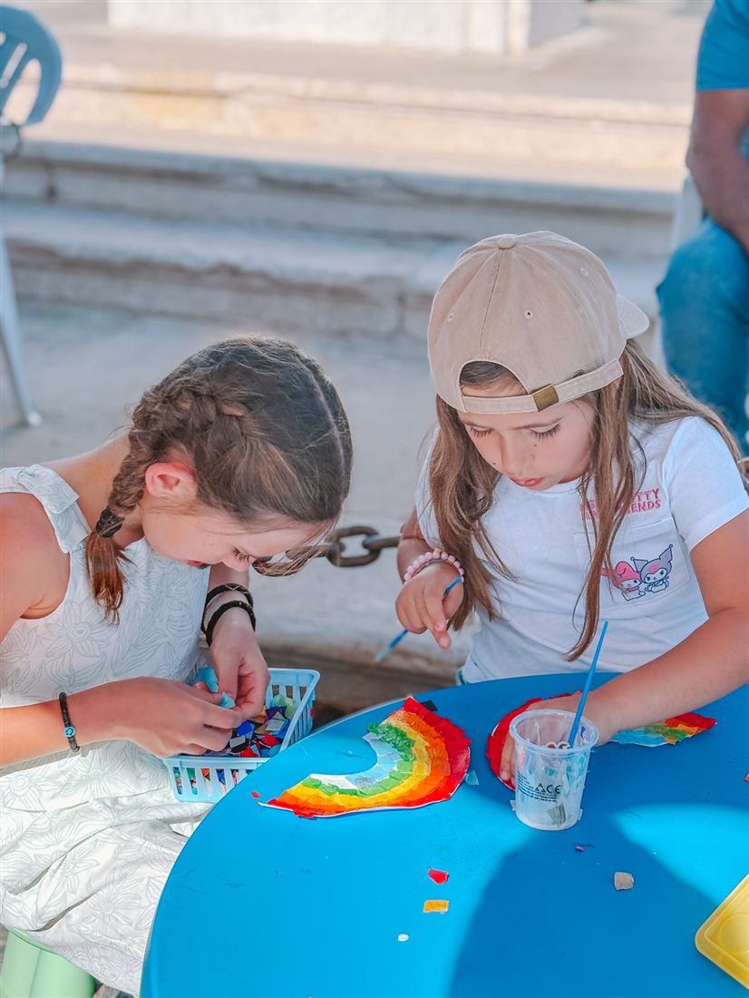 Crianças a pintar numa mesa ao ar livre